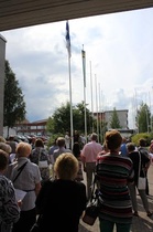 Kuhmotalon edustalla juhlille tulleita Haverisia ja Haveristen jälkeläisiä Suomen lipun ja sukuviirin nostossa.(Kuva: Mauno Haverinen)